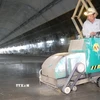 Công nhân thi công hạng mục tạo độ nhám cho mặt đường bên trong hầm. (Ảnh: Hữu Quyết/TTXVN)