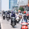 Khẩu trang, áo chống nắng là những thứ không thể thiếu của người dân khi tham gia giao thông trong những ngày nắng nóng. (Ảnh: Lê Đông/TTXVN)