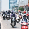 Khẩu trang, áo chống nắng là những thứ không thể thiếu của người dân khi tham gia giao thông trong ngày nắng nóng. (Ảnh: Lê Đông/TTXVN)
