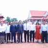 Đại sứ Nguyễn Minh Tâm cùng đoàn đại biểu chụp ảnh kỷ niệm tại Khu lưu niệm Chủ tịch Hồ Chí Minh ở bản Xiengvang, huyện Nongbok, tỉnh Khammouane. (Ảnh: Xuân Tú/TTXVN)