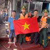 Hội viên Nghiệp đoàn nghề cá, tổ viên tổ đoàn kết trên biển thành phố Đà Nẵng nhận cờ Tổ quốc do Đồn biên phòng cửa khẩu cảng Kỳ Hà trao tặng. (Ảnh: Đoàn Hữu Trung/TTXVN)