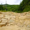 Mặt đường Trà Thanh-Trà Phong bong tróc nặng, lởm chởm đá, sỏi. (Ảnh: Lê Phước Ngọc/TTXVN)