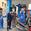Cán bộ Đội Quản lý thị trường số 6, Chi cục QLTT Thanh Hóa có mặt tại cửa hàng xăng dầu để nắm bắt tình hình cung ứng, ổn định thị trường khi giá xăng biến động. (Ảnh: Khiếu Tư/TTXVN)
