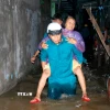 Hỗ trợ người già di chuyển khỏi khu vực ngập sâu đến nơi an toàn. (Ảnh: Nguyễn Thanh/TTXVN)