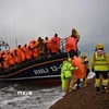 Người di cư được đưa tới bờ biển ở Dungeness, Đông Nam Anh, sau khi được giải cứu trên biển. (Ảnh: Getty Images/ TTXVN)