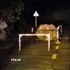 Tảng đá lớn lăn xuống từ vách núi, nằm chắn một phần mặt đường Hồ Chí Minh nhánh Tây. (Ảnh: TTXVN phát)
