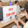 Người dân quét mã QR để tra cứu thủ tục và quy trình hồ sơ thuộc lĩnh vực tư pháp - hộ tịch. (Ảnh: Hữu Duyên/TTXVN)