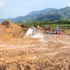 Thực hiện xử lý đất nhiễm chất độc dioxin tại sân bay A So bằng phương pháp sinh học. (Ảnh: TTXVN phát)