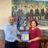 Phó Thị trưởng đảo Rhodes Chalkias Konstantinos tặng sách cho Đại sứ Phạm Thị Thu Hương. (Ảnh: TTXVN phát)