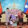 Tổng Giám đốc Thông tấn xã Việt Nam Vũ Việt Trang tặng lẵng hoa chúc mừng Đại sứ Lào tại Việt Nam Khamphao Ernthavanh nhân dịp kỷ niệm 50 năm Quốc khánh nước CHDCND Lào. (Ảnh: Hoàng Hiếu/TTXVN)