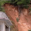 Một điểm sạt lở, sụt lún phía sau nhà dân ở thôn Lạc Thiện 2 vẫn tiếp tục lở đất vào trưa 24/11/2025. (Ảnh: Nguyễn Dũng/TTXVN)