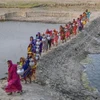 Phụ nữ tại Khulna (Bangladesh) mang nước từ nguồn nước ngọt ở xa sau khi nguồn nước uống tại địa phương bị ảnh hưởng bởi xâm nhập mặn và các vấn đề khác. (Nguồn :Getty Images)