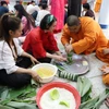 Các chú tiểu tại Chùa Phổ Phước rất quan tâm tìm hiểu văn hóa phong tục tập quán đón Tết của Việt Nam qua việc gói bánh chưng, bánh tét. (Ảnh: Đỗ Sinh/TTXVN)
