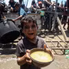 Em nhỏ Palestine nhận thức ăn cứu trợ tại thành phố Gaza, ngày 24/7/2025. (Ảnh: THX/TTXVN)