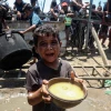 Em nhỏ Palestine nhận thức ăn cứu trợ tại thành phố Gaza, ngày 24/7/2025. (Ảnh: THX/TTXVN)