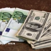 Đồng tiền giấy mệnh giá 100 euro (trái) và 100 USD tại Paris (Pháp). (Ảnh: )AFP/TTXVN