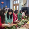 Các phu nhân cán bộ, nhân viên Đại sứ quán và các cơ quan bên cạnh Đại sứ quán tại Nga tham gia gói bánh chưng. (Ảnh: Trần Hải/TTXVN)