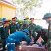Lực lượng chuyên trách tiến hành khai quật mộ liệt sỹ. (Ảnh: Mai Trang/TTXVN)
