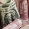 Đồng nhân dân tệ và đồng USD. (Ảnh: AFP/TTXVN)
