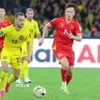 Nỗ lực đi bóng của Hoàng Đức (14-tuyển Việt Nam) trước các cầu thủ Malaysia. (Ảnh: TTXVN phát)