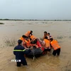 Lực lượng Cảnh sát phòng cháy chữa cháy Công an tỉnh Quảng Ngãi cưỡng chế đưa người dân giữa dòng sông Trà Khúc vào bờ. (Ảnh: TTXVN)