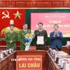 Chủ tịch Ủy ban Nhân dân tỉnh Lai Châu, Hà Quang Trung tặng hoa và trao thư khen của Thủ tướng Chính phủ cho Ban Giám đốc Công an tỉnh Lai Châu. (Ảnh: Quý Trung/TTXVN)