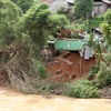 Một ngôi nhà chênh vênh đối mặt nguy cơ sạt lở bên sông Nậm Mộ. (Ảnh: Văn Tý/TTXVN)