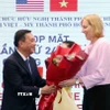 Ông Phạm Thành Kiên tặng hoa chúc mừng bà Susan Burns, Tổng lãnh sự Hoa Kỳ tại Thành phố Hồ Chí Minh. (Ảnh: Xuân Khu/TTXVN)