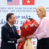 Ông Phạm Thành Kiên tặng hoa chúc mừng bà Susan Burns, Tổng lãnh sự Hoa Kỳ tại Thành phố Hồ Chí Minh. (Ảnh: Xuân Khu/TTXVN)