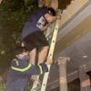 Người bị nạn được lực lượng chức năng hỗ trợ thoát khỏi ngôi nhà qua thang. (Ảnh: Công an cung cấp)