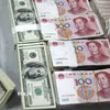 Nhân viên kiểm đồng USD và nhân dân tệ. (Ảnh: AFP/TTXVN)