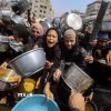 Người tị nạn Palestine nhận thức ăn cứu trợ tại thành phố Gaza. (Ảnh: THX/TTXVN)