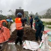 Ôtô chở đá bây, cát cho vào bao tải gia cố đê sông Thị Long thuộc phường Ngọc Sơn (Thanh Hóa). (Ảnh: Việt Hoàng/TTXVN)