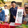 Du khách được tặng chữ thư pháp đầu năm mới Bính Ngọ ở Thế Miếu, Đại Nội Huế. (Ảnh: Nguyên Lý/TTXVN)