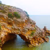 Nhìn từ trên cao, khu vực hang Mũi Trâu như một khuôn mặt người đang nhìn ra biển, cửa hang ngập trong nước khi thủy triều dâng cao. (Ảnh: Xuân Tiến/TTXVN)