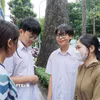 Thí sinh chia sẻ niềm vui với phụ huynh và bạn bè sau khi hoàn thành tốt bài thi. (Ảnh: Thu Hoài/TTXVN)