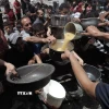 Người dân Palestine nhận thức ăn cứu trợ tại trại tị nạn Jabalia, miền Bắc Dải Gaza ngày 19/5. (Ảnh: THX/TTXVN)