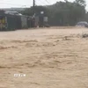 Mưa lớn khiến cho tuyến đường tại phường Vũng Áng ngập, nước chảy xiết. (Ảnh: TTXVN phát)