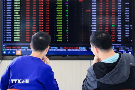 Nhà đầu tư theo dõi bảng chỉ số chứng khoán tại Giang Tô, Trung Quốc. (Ảnh: THX/TTXVN)