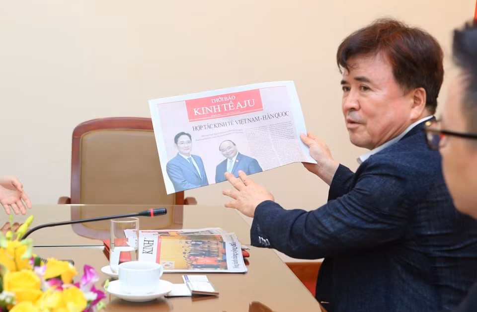 Chủ tịch Aju News Corporation, Chủ tịch Tiểu ban Việt Nam thuộc Hiệp hội Doanh nghiệp vừa và nhỏ, ông Kwak Young-kil giới thiệu tờ Thời Báo Kinh tế Aju phiên bản tiếng Việt. (Ảnh: Thành Đạt/TTXVN)
