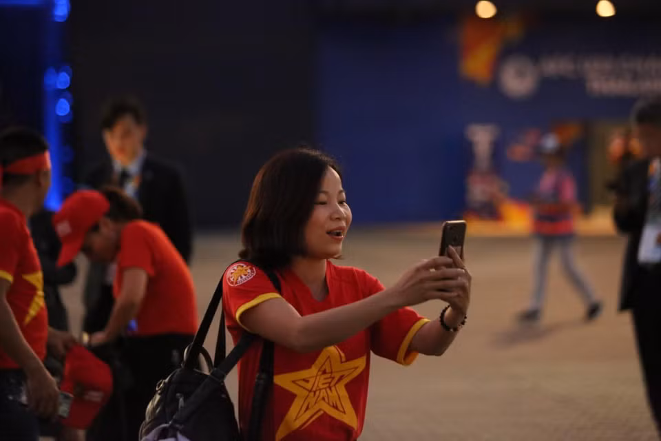 Các nữ cổ động viên tranh thủ chụp hình trước khi vào sân. (Ảnh: Nguyên An/Vietnam+)