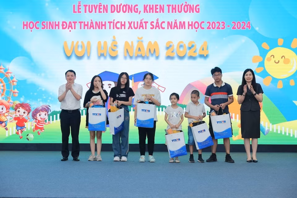 Phó Bí thư Thường trực Đảng ủy TTXVN Đỗ Thị Trang và Chủ tịch Công đoàn, Trưởng Ban Tổ chức-Cán bộ TTXVN Đỗ Mạnh Chiến trao thưởng tuyên dương học sinh đạt giải cấp tỉnh, thành phố. (Ảnh: Hoàng Hiếu/TTXVN)