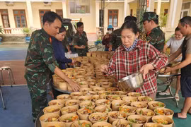 Cục Hậu cần – Kỹ thuật Quân khu 5 tổ chức nấu, cấp phát suất ăn, nước uống, thuốc men hỗ trợ người dân ở vùng ngập sâu. (Ảnh: PV/Vietnam+)