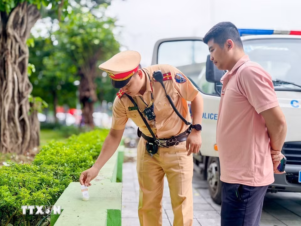 Lực lượng Cảnh sát giao thông thực hiện test nhanh ma túy đối với lái xe kinh doanh vận tải trên tuyến Khuất Duy Tiến. (Ảnh: Trung Nguyên/TTXVN)