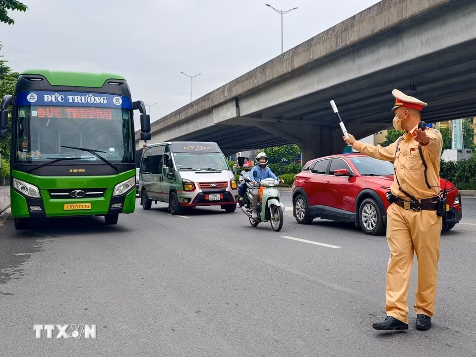 Cảnh sát giao thông Hà Nội hướng dẫn xe khách vào vị trí kiểm tra trong đợt tổng kiểm soát phương tiện kinh doanh vận tải, ngày 26/8/2026. (Ảnh: Trung Nguyên/TTXVN)