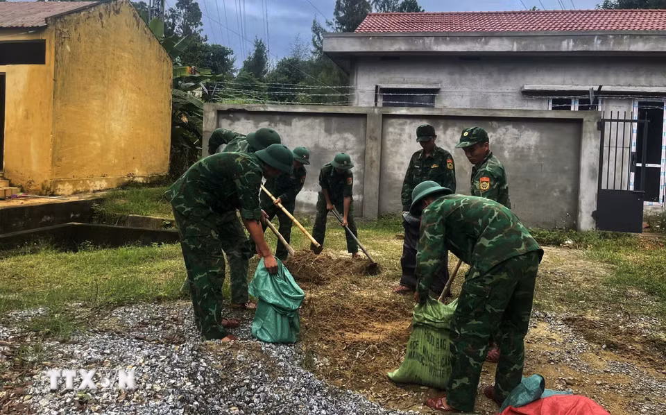 Đồn biên phòng cửa khẩu cảng Kỳ Hà sử dụng bao tải chứa đất đá và nước để chằng mái nhà khỏi bị gió bão 12 quăng quật. (Ảnh: Đoàn Hữu Trung/TTXVN)