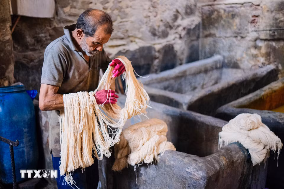 Một người thợ nhuộm các cuộn sợi tại xưởng nhuộm Salama ở Cairo, Ai Cập, ngày 16/9/2026. (Ảnh: THX/TTXVN phát) ả