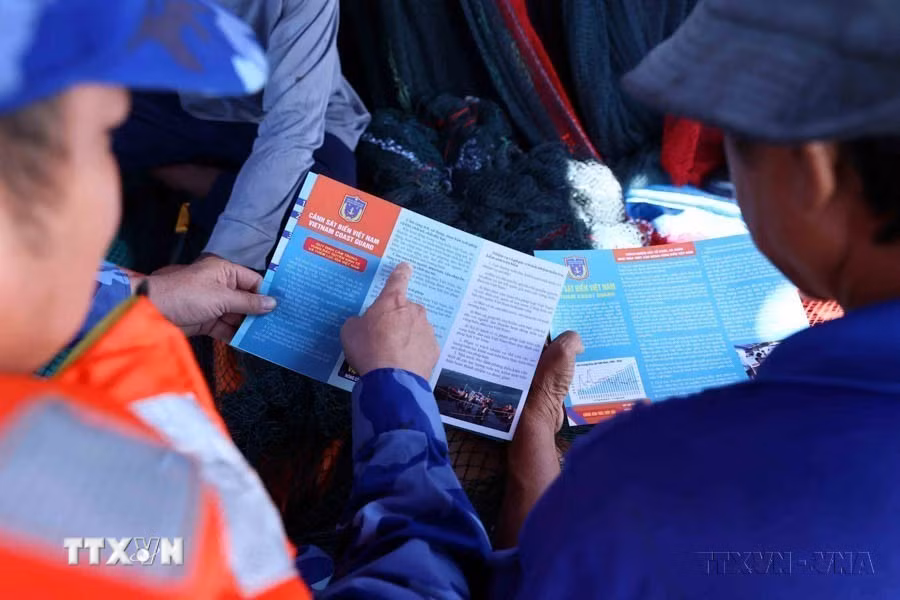 Lực lượng Cảnh sát biển Việt Nam phát tờ rơi tuyên truyền pháp luật cho ngư dân trên khu vực biển quanh quần đảo Thổ Chu (Kiên Giang). (Ảnh: An Đăng/TTXVN)