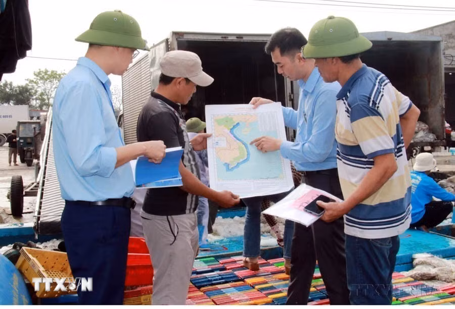 Trao tặng bản đồ cho ngư dân Nam Định trước khi ra khơi. (Ảnh: Nguyễn Lành/TTXVN)