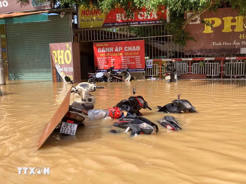 Xe máy đổ la liệt ngập sâu trong nước tại phường Quan Triều, tỉnh Thái Nguyên. (Ảnh: Thắng Trung/TTXVN)